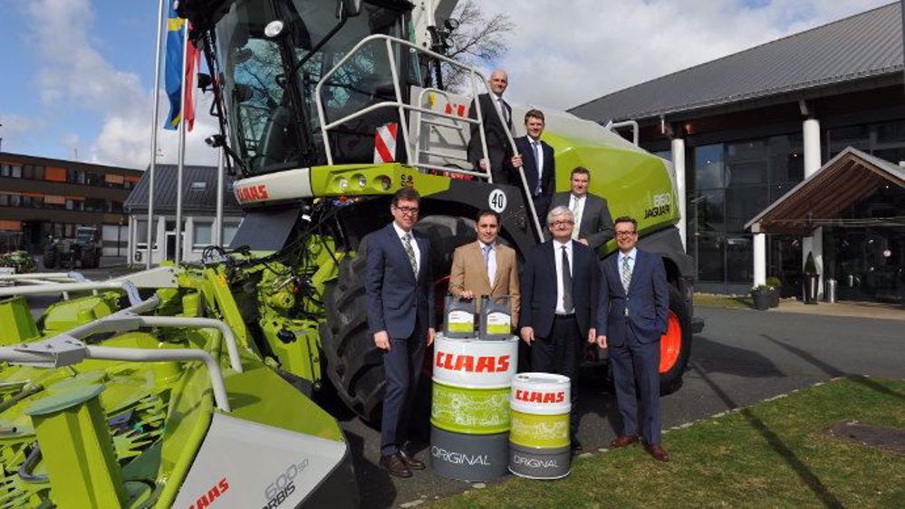 Les dirigeants des deux entreprises posent devant une ensileuse Claas Jaguar. (©Total)