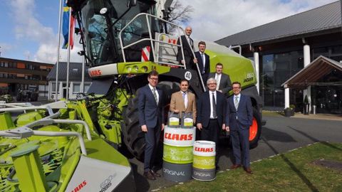Les dirigeants des deux entreprises posent devant une ensileuse Claas Jaguar. (©Total)
