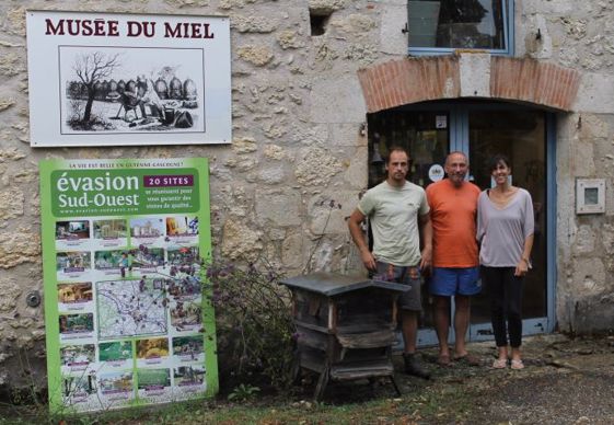 Chantal, Émile et Aymeric devant l'entrée du Musée du miel.
