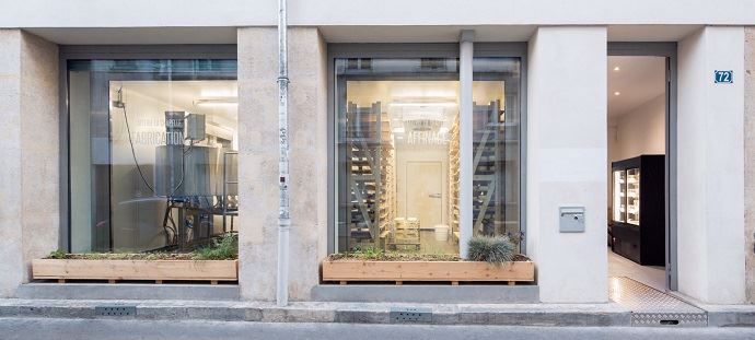 C'est au rez-de-chaussée d'un immeuble du 18e arrondissement de Paris que la Laiterie La Chapelle a pris ses quartiers. Grâce aux grandes vitrines, les passants peuvent assiter à la transformation (à gauche) et à l'affinage des fromages (à droite).