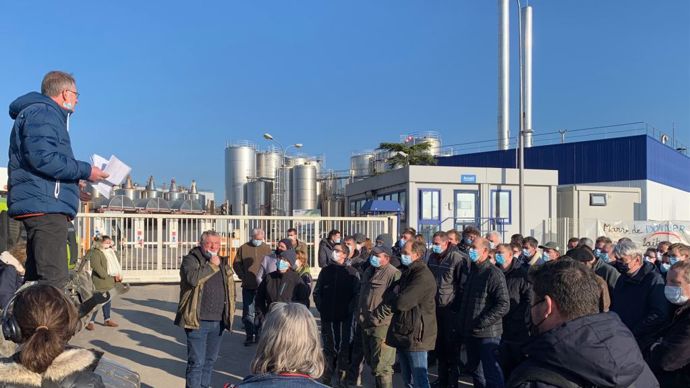 Hubert Dion, président de l'OP, devant l'usine et les manifestants.