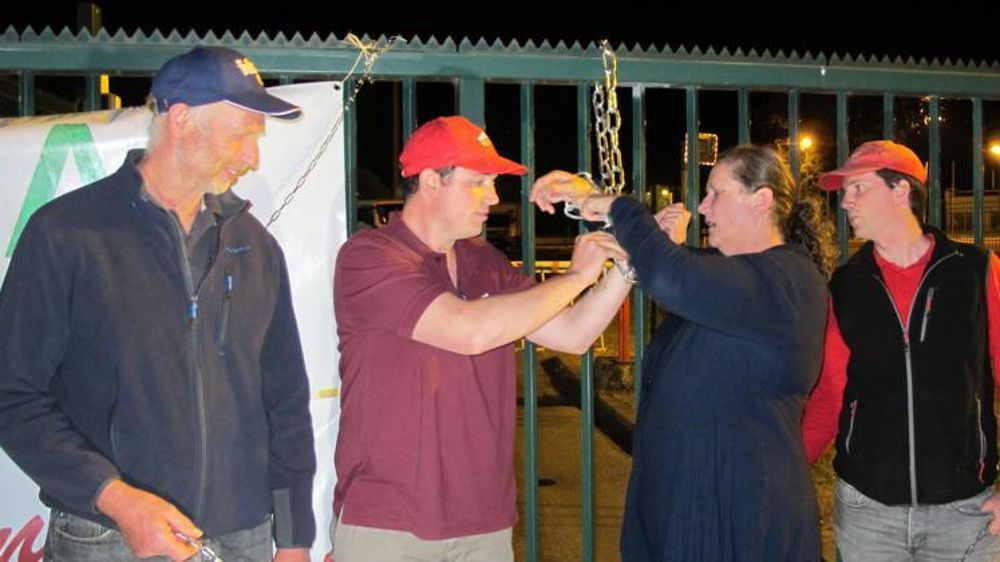 Symboliquement, cinq manifestants se sont enchaînés aux grilles de l’usine Lactalis de Domfront (Orne), le 3 août 2016.© C. Hue