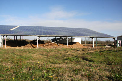 Un hangar photovoltaïque sert au stockage des plaquettes de bois et du matériel. © H. Quenin