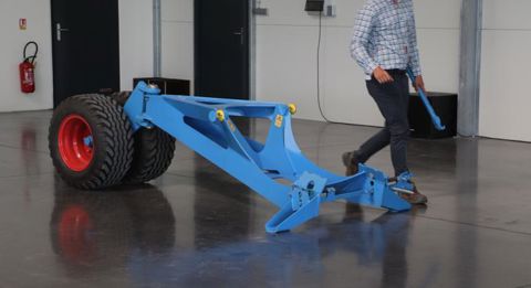 Un dispositif muni de deux roues et d’une articulation vient se positionner sous le bâti du combiné lors du transport, pour diminuer le poids sur l’essieu arrière du tracteur. © P. Peeters
