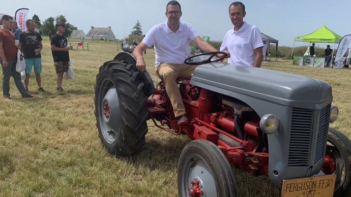 Régis Morvan (à g.), dirigeant de Douar Appro, sur son tracteur Ferguson de 1957, accompagné de Marc Ancel, directeur commercial, lors de leur journée « Champs d’avenir », le 16 juin. Un défilé de tracteurs anciens clôturait cette journée. © H. LAURANDEL.