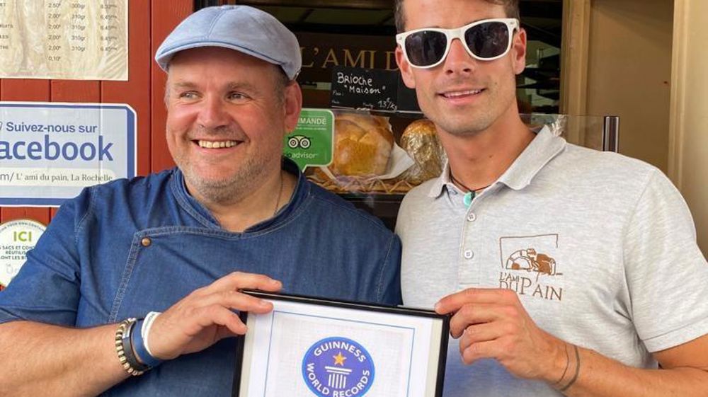 Père et fils devant la petite façade de boulangerie