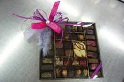 Un ruban, quelques plumes et une perle savamment noués métamorphosent une boîte de chocolats. Boîte de chocolats décorée (Photo : Latoque.fr)