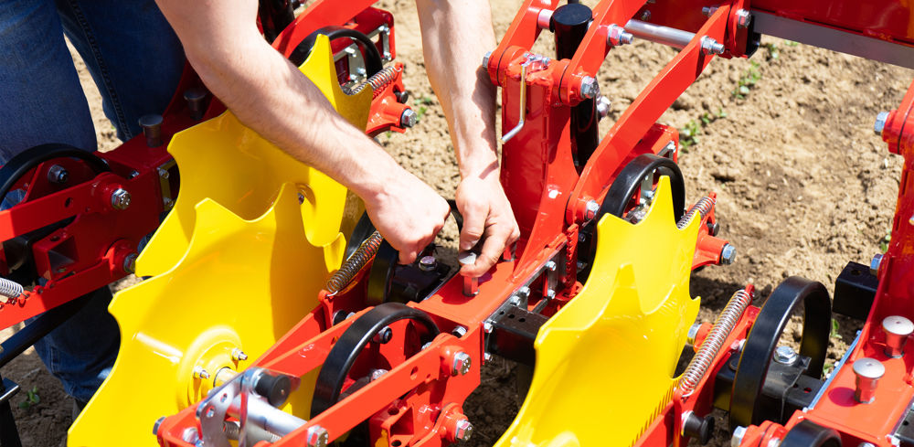 La bineuse Pöttinger se démarque, en se réglant entièrement sans outil. Tout est verrouillé par des petites poignées, y compris le réglage de l’écartement entre rangs.
