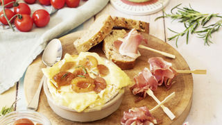 Répartissez les mirabelles sur le fromage et servez avec des pics de jambon cru et des toasts de pain.