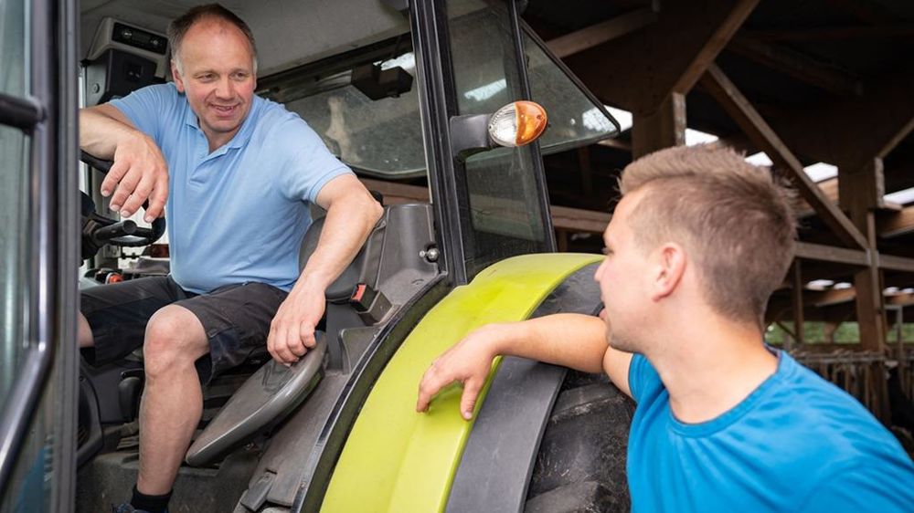 Agriculteur jeune et plus vieux avec un tracteur