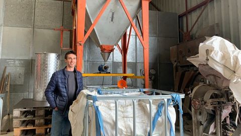 Florian Ballot devant sa presse à huile de colza et tournesol