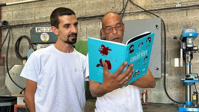 Jérôme Beuchot et Tebari Bouchaib, tous deux électriciens sur les sites de Dijon céréales, en pleine lecture d’un livre de la bibliothèque éphémère sur l’égalité hommes-femmes mise en place par le CSE de la coopérative.
