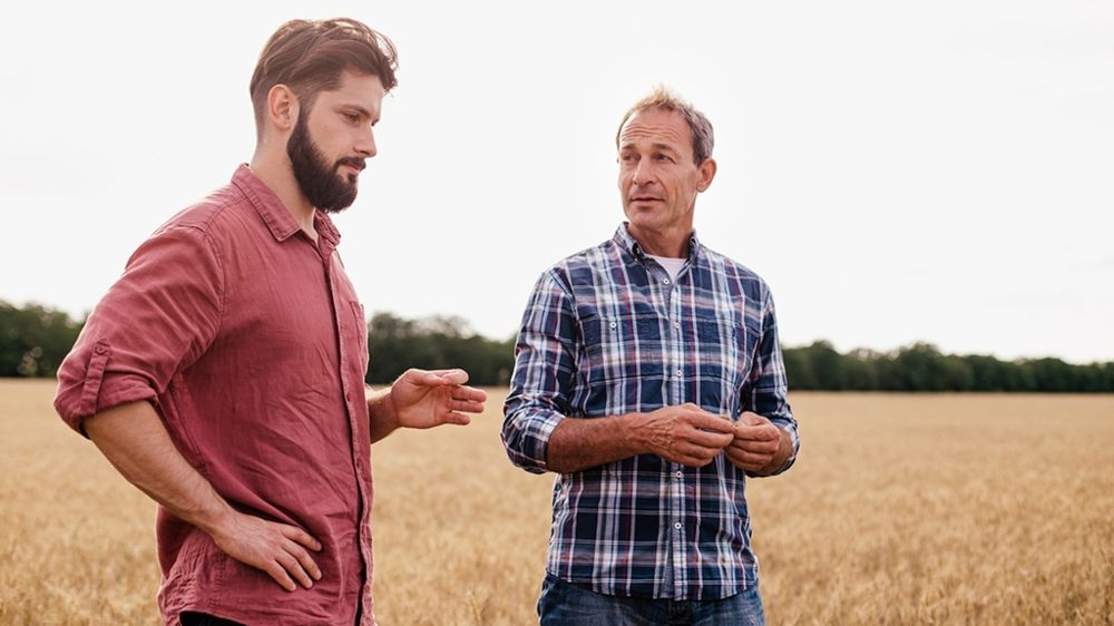 Cédant et repreneur dans un champ de blé