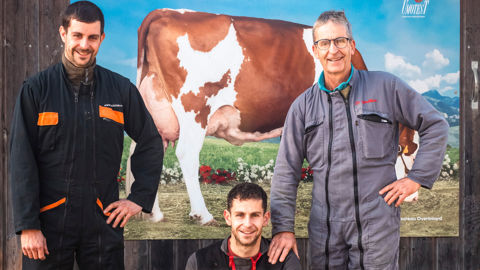 Olivier Hugueny et ses deux fils, Simon et Guillaume à l’entrée de leur stabulation devant la grande photo de la vache Lancia, mère du taureau Overboard.  Au pied des Vosges, la famille Hugueny élève un troupeau laitier de 87 montbéliardes sur 173 ha de SAU dont 104 ha d’herbe. 
Installé hors cadre familial après une expérience de conseiller agricole, Olivier Hugueny a donné à ses deux fils, Simon et Guillaume, l’envie de le rejoindre sur la ferme (respectivement en 2013 et 2019).
Installé hors 
