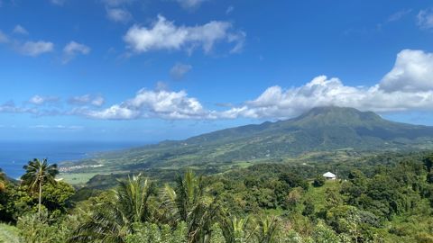 La montagne Pelée, souvent couronnée de nuages, surplombe la ville de Saint-Pierre et sa baie.