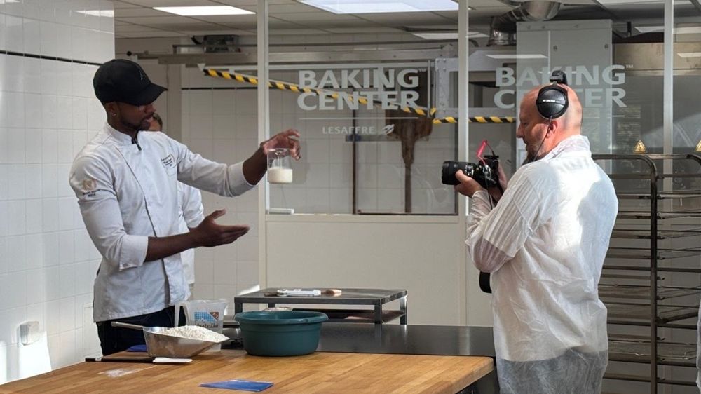 Xavier Netry montrant un récipient rempli de levain liquide lors du premier épisode, intitulé “Comment rafraîchir son levain”, à l’objectif de Christophe Lopacki.