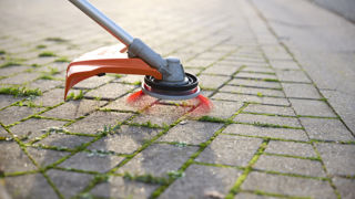 La tête de débroussailleuse universelle « 2 en 1 » peut servir au débroussaillage ou au nettoyage des surfaces dures.