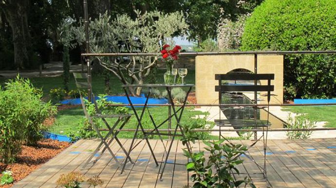 08. La terrasse en bois, surélevée, avec vélum en fils d'inox, donne un autre angle de vue et permet d'apprécier le jardin et son cadre environnant : platanes séculaires, vieux mas, campagne environnante… L'olivier, les lavandes, donnent des tonalités de bleu et évoquent la garrigue régionale et la Provence toute proche.