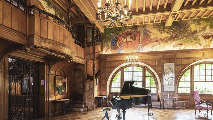 Le balcon intérieur du grand hall et les miroirs sur les volets à galandages illustrent l'ambiance théâtrale qu'a voulue Edmond Rostand.
